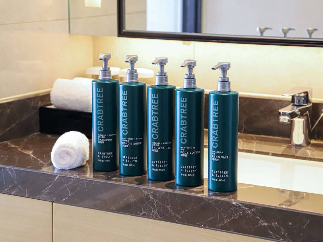 The Crabtree & Evelyn 5-piece toiletries set displayed on the sink includes shampoo, conditioner, body lotion, shower gel, and hand soap.